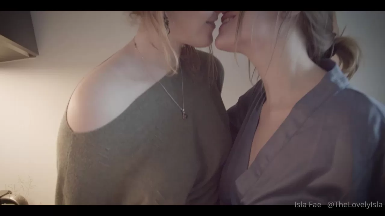Two Women Embrace and Kiss in a Cozy Kitchen Scene