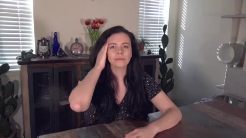 Woman with Long Dark Wavy Hair in Grey Cardigan and Black Patterned To