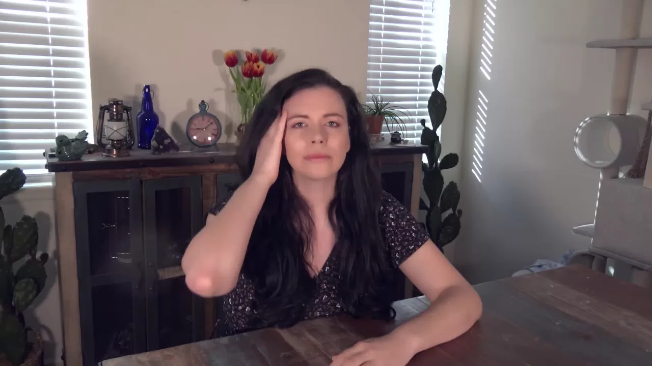 Woman with Long Dark Wavy Hair in Grey Cardigan and Black Patterned To