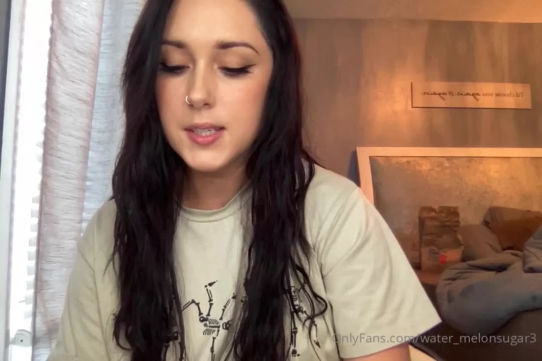 Young Woman with Dark Hair and Nose Piercing in Bedroom