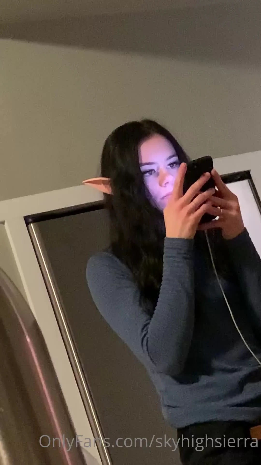 Woman with Elf Ears Using Smartphone in Low Light