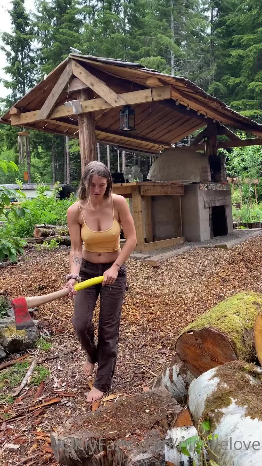 Tattooed Brunette Chops Wood Barefoot in Forest Outdoors