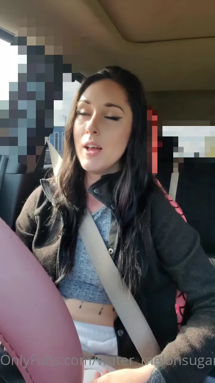 Brunette with abdomen tattoos talks in car