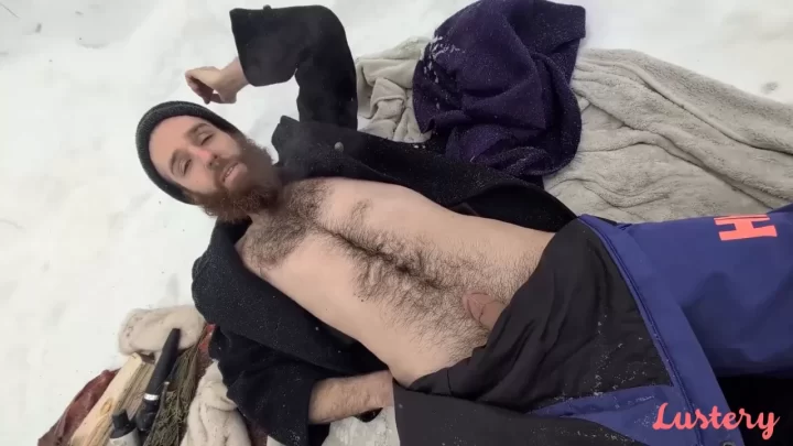 Two white guys suck and cuddle in the snow with firewood nearby
