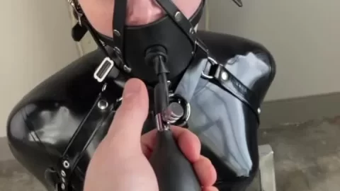 Restrained Redhead in Latex Bodysuit Gagged in Industrial Room