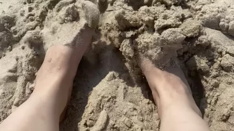 POV Beach Feet with Pink Nail Polish on Sand
