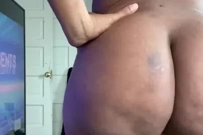 Curvy Dark-Skinned Person with Locs Posing in Bedroom