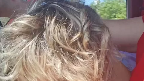 Blonde gives blowjob in red car, natural light close-up