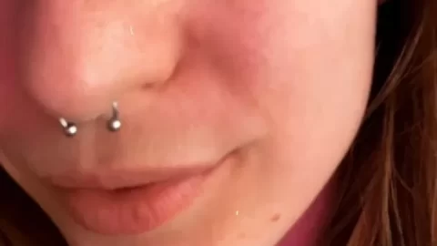 Redhead with piercings plays with tongue