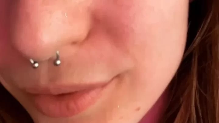 Redhead with piercings plays with tongue