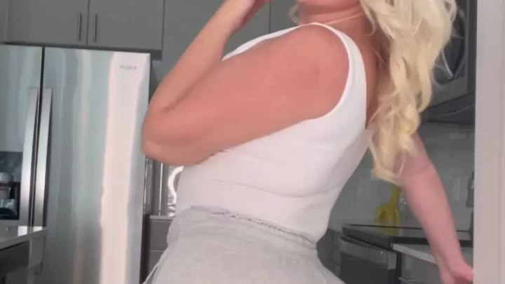 Blonde woman posing and looking at camera in kitchen