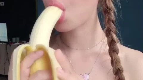 Teen blonde eats banana in bedroom