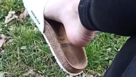 Slim 20s Girl with Black Toenails Puts on Shoes Outdoors
