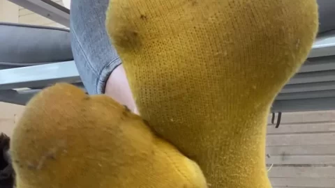 Blonde girl sits on porch, smokes and shows feet