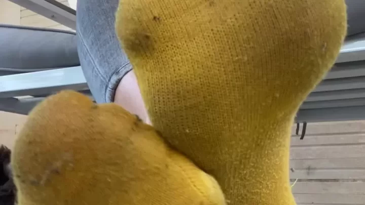 Blonde girl sits on porch, smokes and shows feet