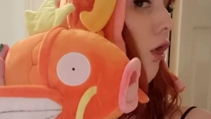 Redhead girl plays with orange fish hat