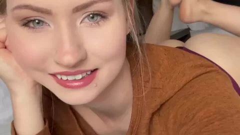 Blonde girl lays on bed, selfie close-ups