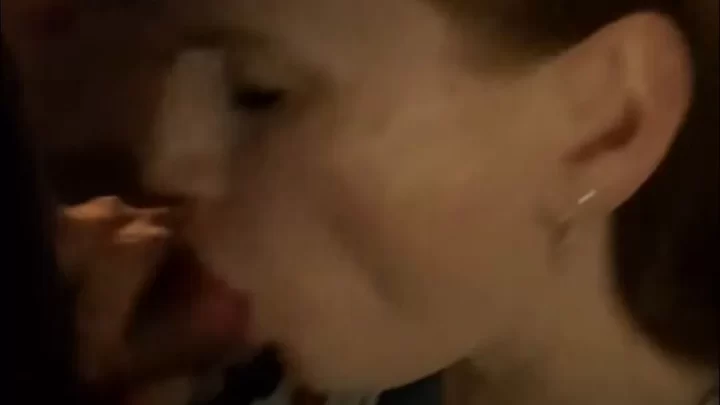 Brunette girl kisses guy by fireplace