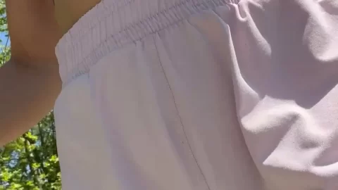 Slim White Girl Lifts Shorts Outdoors