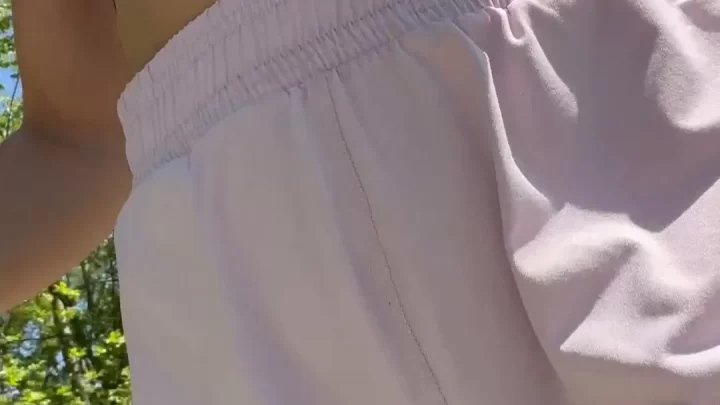 Slim White Girl Lifts Shorts Outdoors