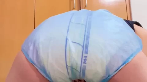 Asian woman in diaper and pacifier exposes breasts