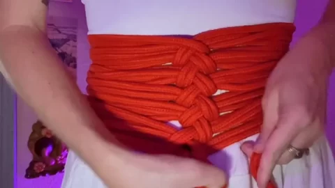 Slim 20s woman with purple hair and tattoos ties herself up