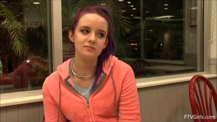Slim white girl with neck tattoo talks while sitting
