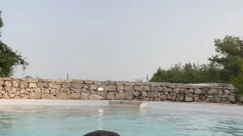 Brunette teen girl swimming nude in pool
