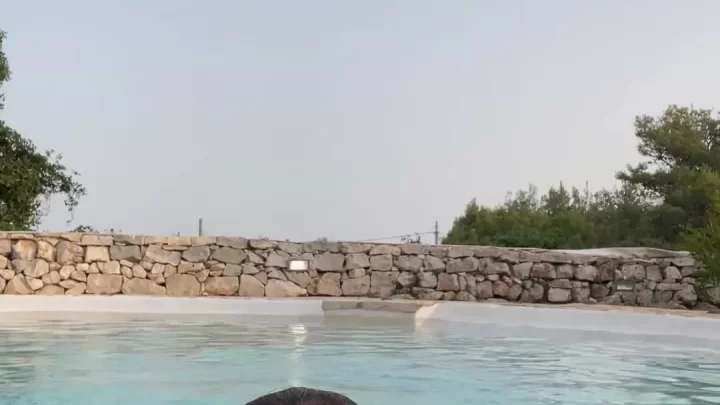 Brunette teen girl swimming nude in pool