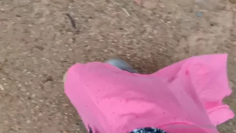 Slim girl in pink pants walks on dirt path