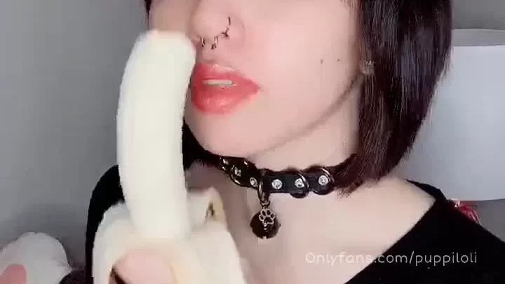 Asian girl eats banana in bedroom