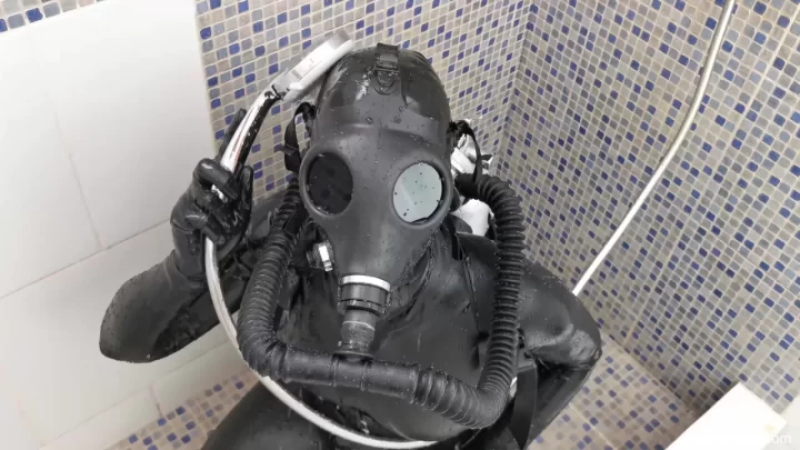 Slim girl in black latex bodysuit and gas mask fucks herself in shower