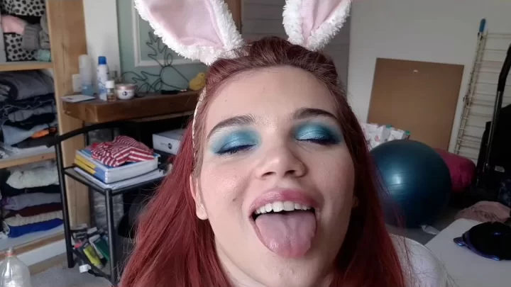 Redhead teen with blue eyeshadow plays with candy