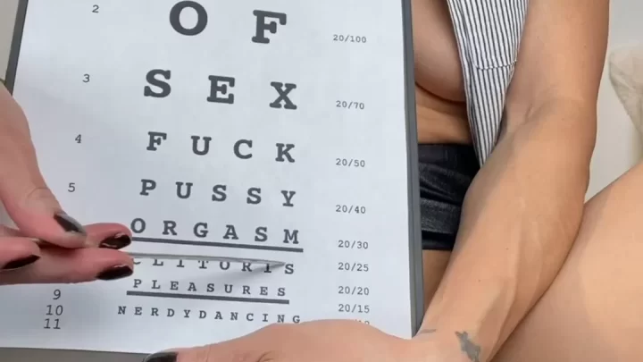Slim brunette holds eye chart with explicit words