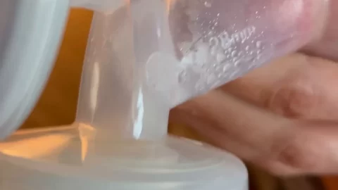 Blonde girl pumping breast milk