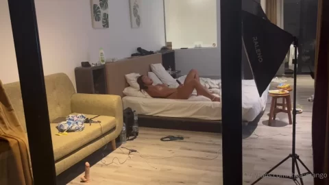Brunette Girl Lying on Bed, Holding Phone