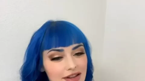 Slim blue-haired girl poses and looks around