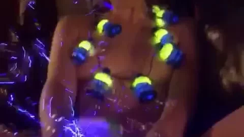 Redheaded girl plays with glowing toys topless