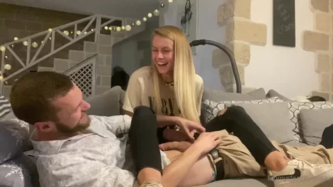 Blonde woman on white guy’s lap, casual setting