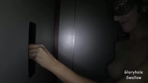 Slim brunette in masquerade mask gives blowjob through glory hole