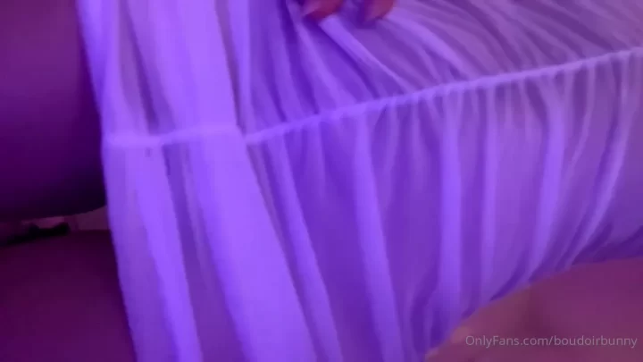 Blonde Girl Adjusting White Dress in Purple Bedroom
