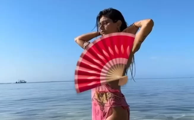 Asian Girl in Pink Dress Plays with Fan in Shallow Water