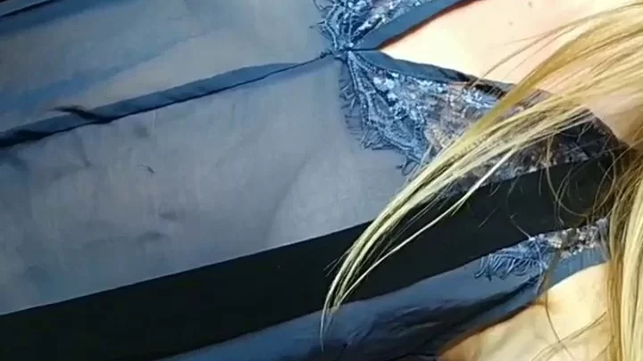 Blonde girl lies on bed in blue dress