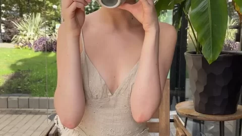 Redhead girl drinks coffee alone