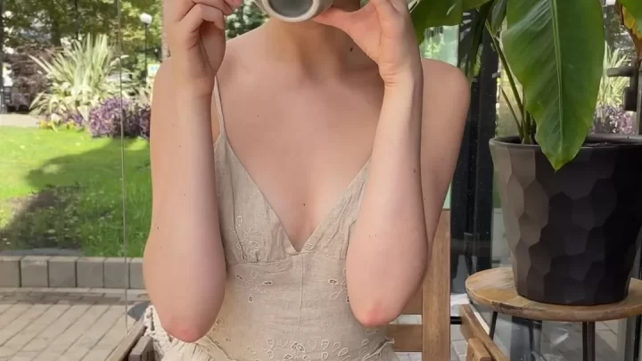 Redhead girl drinks coffee alone