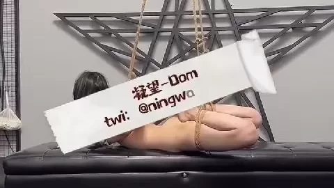 Asian woman in black bondage suspended by ropes