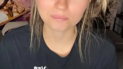 Blonde girl sits on couch, looks at camera