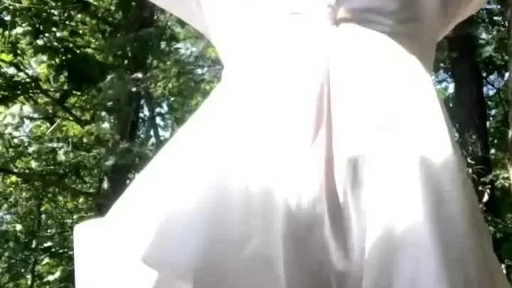 Blonde woman dancing outdoors, shows black underwear