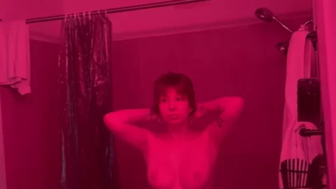 Brunette with tattoos poses nude in bathroom