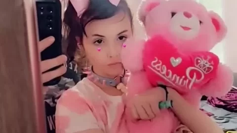 Petite brunette with pink bow bends over